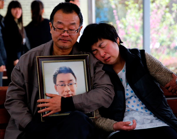 The parents of Wei Zexi, a computer science major at Xidian University in Shaanxi province who died of a rare form of cancer, wait outside a funeral home in Xianyang, Shaanxi, on April 13. WAN JIA / FOR CHINA DAILY
