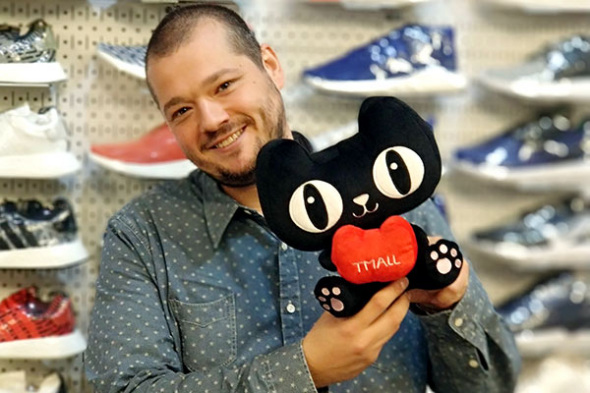 John McPheters, co-founder and CEO of Stadium Goods, holds the Tmall mascot in New York on Oct. 31, 2017. (Photo/China Daily)