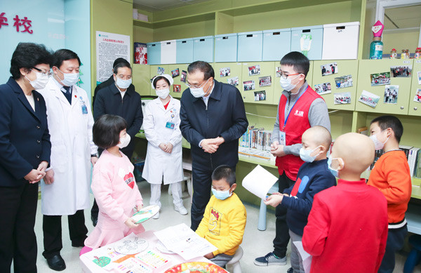 Premier Li Keqiang visits young leukemia patients and volunteers in the Wuhan Union Hospital on Tuesday. His two-day visit to Hubei province included discussions of free trade zones and the need for higher-quality development. (Photo/Xinhua)