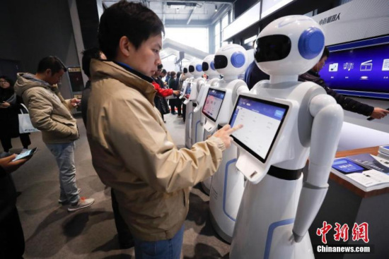 A visitor interacts with an intelligent robot at the Light of Internet Exposition of the fourth World Internet Conference in Wuzhen, Tongxiang City of east China's Zhejiang Province, Dec. 4, 2017. (Photo: China News Service/Du Yang)