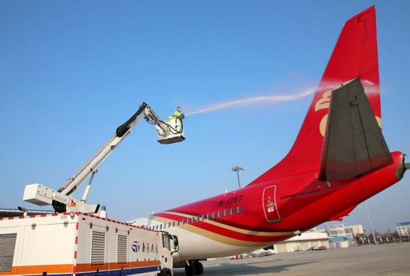 An employee carries out ice prevention operations on an airplane at the Nantong Xingdong International Airport in Jiangsu province. Photo by Xu Congjun/For China Daily