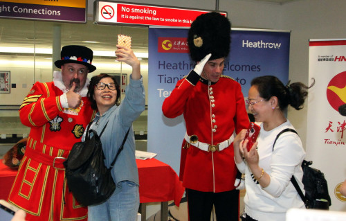 Chinese passengers pose for photographs at London's Heathrow Airport, after the direct air route opened on Monday between Xi'an, Northwest China's Shaanxi Province, and London. (Photo/CHINA NEWS SERVICE)