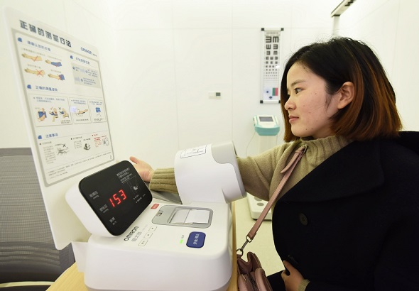 A visitor tests her own blood pressure using a machine at the WeDoctor general practice center in Hangzhou, Zhejiang province. (Photo by Long Wei/For China Daily)