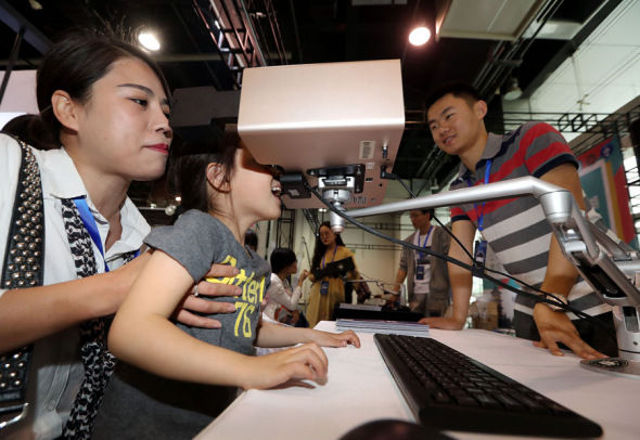 A mom helps her daughter watch a short film on a multi-sensory viewer that can emit aromas, scents and smells related to the content, at the 2018 High-tech Unicorn Enterprise Exhibition held in Hangzhou, Zhejiang province, on April 29. Products like high-tech video viewers distinguish China's unicorns. Photo by Lin Yunlong/For China Daily