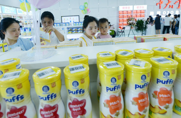 Customers pick imported milk powder cans at an e-trade expo. (Photo by Zhang Tao/For China Daily)