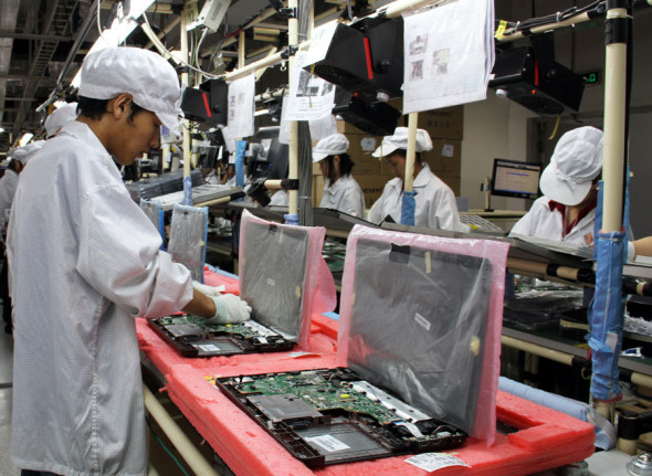 Foxconn employees assemble laptops at a facility in Chongqing. (Photo provided to China Daily)
