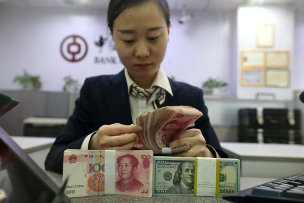A bank clerk counts cash in Taiyuan, capital of Shanxi province. (Photo by Zhang Yun/China News Service)