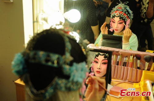 Kun Opera performers have the make-up applied backstage in Chenzhou, Central China's Hunan province, November 27, 2014. (Photo:China News Service/Yang Huafeng)