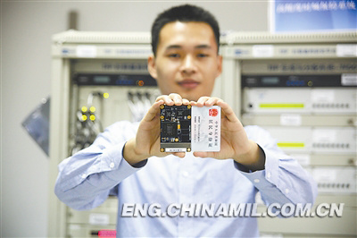 A technician shows the ID-card-sized high-performance satellite navigation receiver. (Chinamil.com.cn / Ge Linnan)