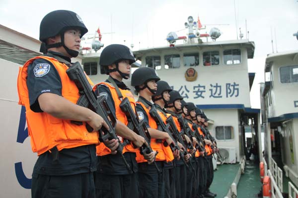 Chinese police officers stand guard aboard a patrol boat on the Mekong River in November. Qin Lang / Xinhua 
