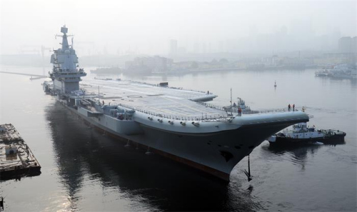 China’s first domestically designed aircraft carrier, which displaces 50,000 metric tons, leaves the Dalian Shipbuilding Industry’s shipyard in Liaoning province on Sunday. (LI GANG/FOR CHINA DAILY)