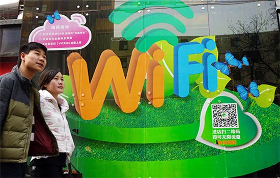 A couple pass by a big advertisement promoting free Wi-Fi service at a mall in Zhengzhou, Henan province. (Photo/China Daily)