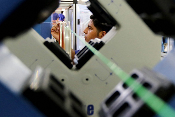 A staffer checks a fiber-optic cable at Latamfiberhome Plant in Duran, Guayas province, Ecuador, on Aug. 26, 2016. (Photo/Xinhua)