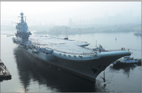 China's first domestically designed aircraft carrier, which displaces 50,000 metric tons, leaves the Dalian Shipbuilding Industry's shipyard in Liaoning province on Sunday. (Li Gang/For China Daily)